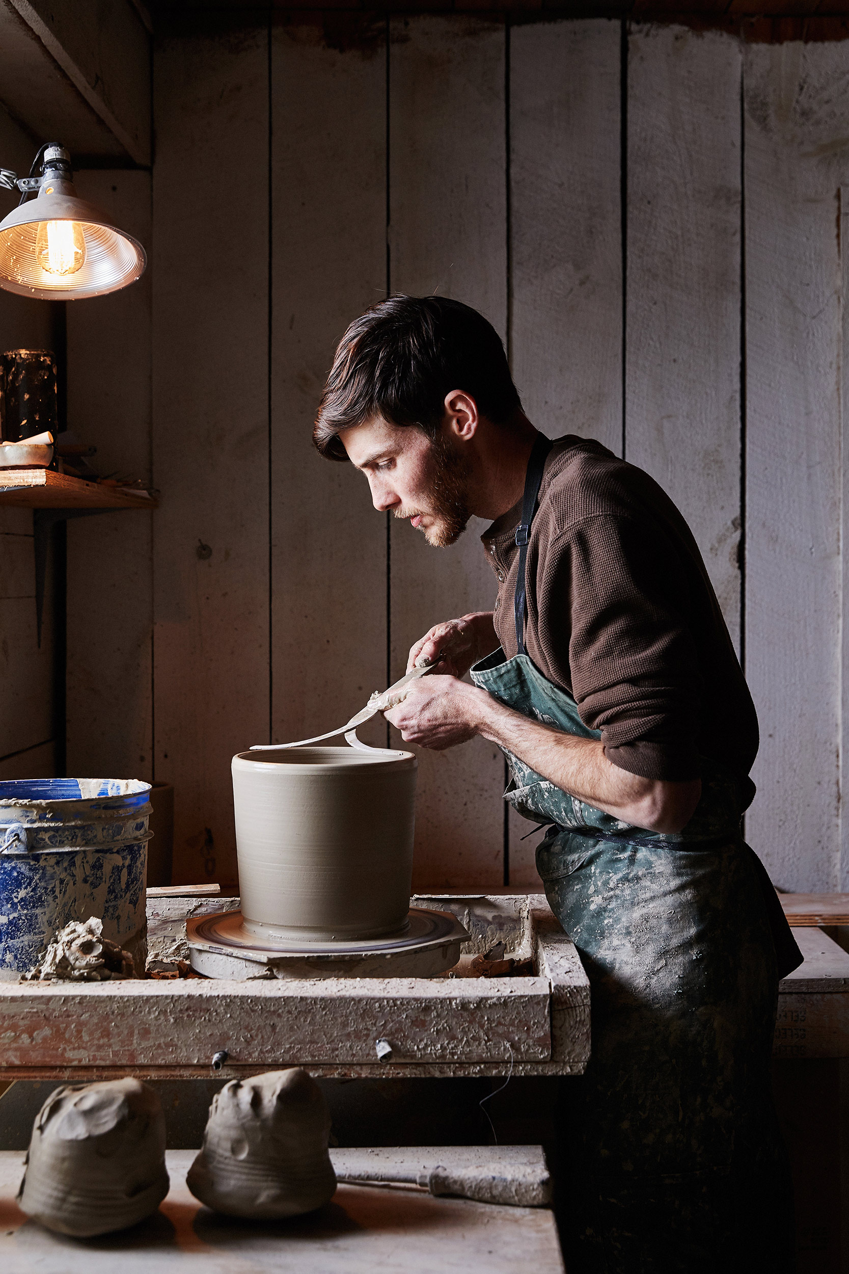 Portrait of a ceramic artist working in his studio by photographer Nico Schinco. 