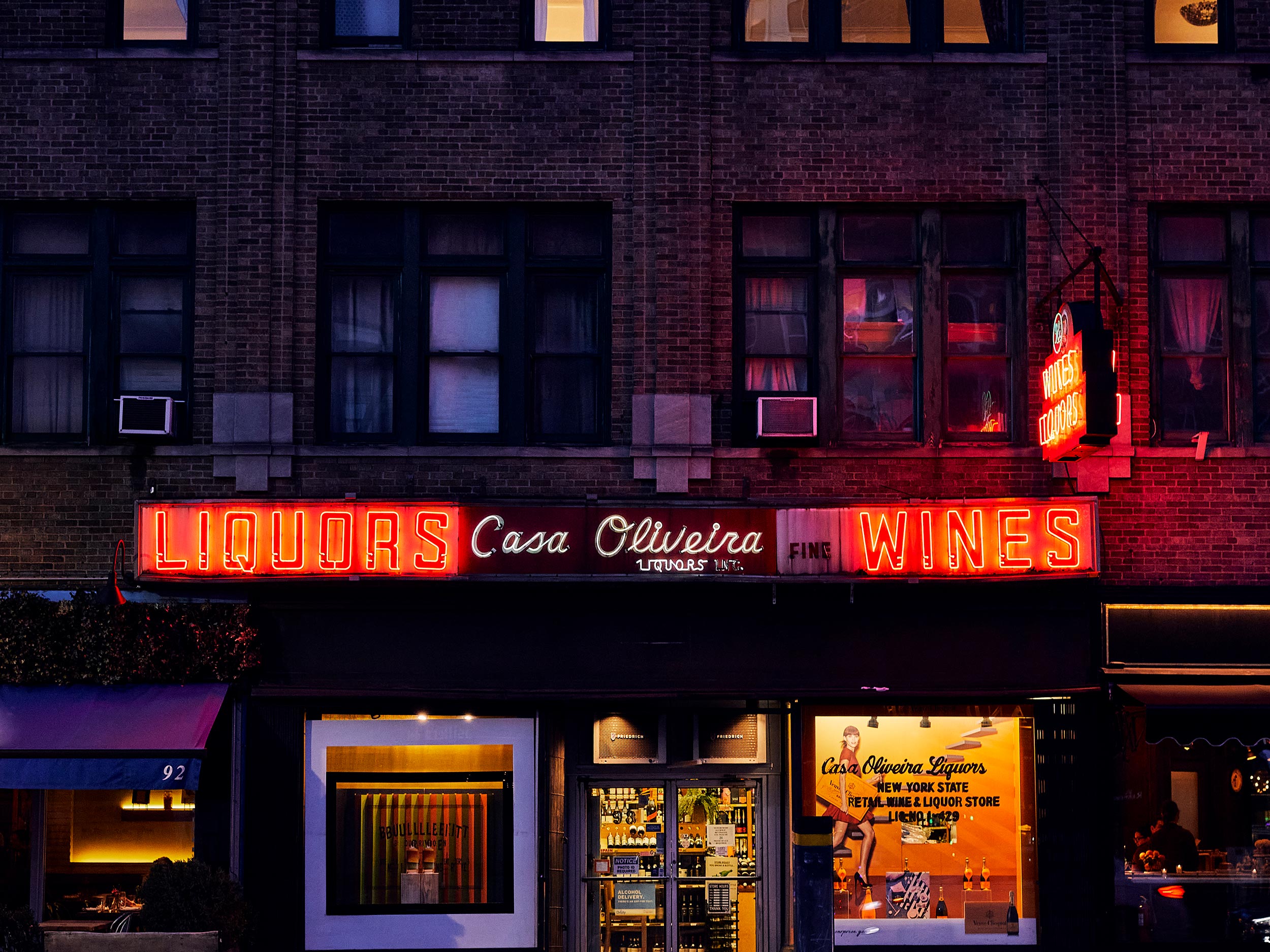 New York City liquor store at night with neon sign photographed by Nico Schinco